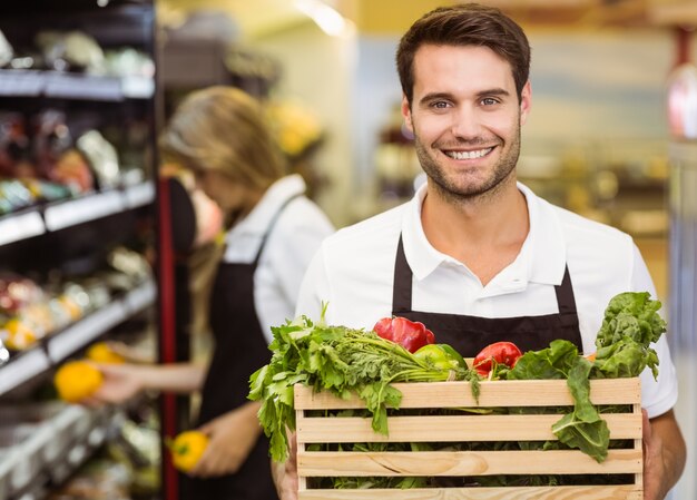 Portret uśmiechnięty pięcioliniowy mężczyzna trzyma pudełko świezi warzywa