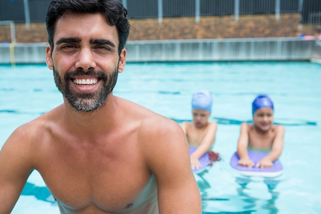 Portret uśmiechnięty trener siedzi przy basenie w centrum rekreacji
