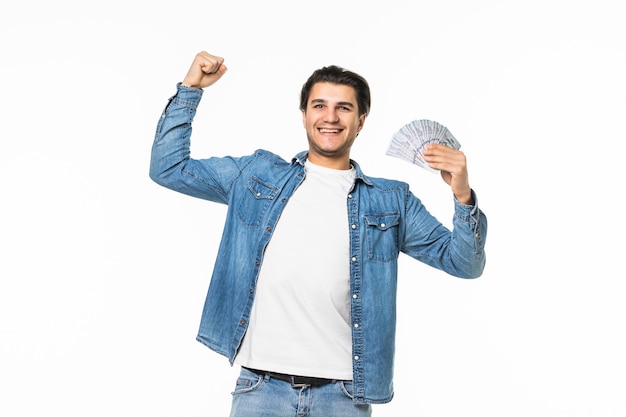 Portret wesołego mężczyzny sukcesu w białej koszuli pokazujący kilka banknotów pieniędzy w dwóch rękach, stojąc i świętując na białym tle