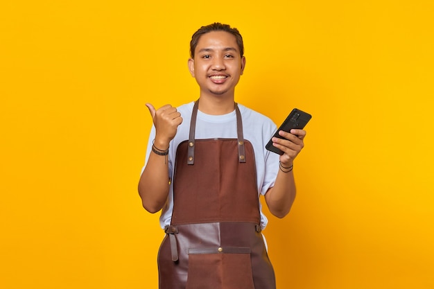 Portret wesołego pozytywnego mężczyzny trzymającego smartfon z palcem pokazującym zniżki sprzedaży