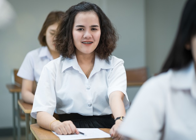 Portret Wesołej Azjatyckich Studentek College'u Pisania I Nauki W Klasie. Selektywni Fous Nastoletnich Studentów Uniwersytetu Studiujących W Klasie.