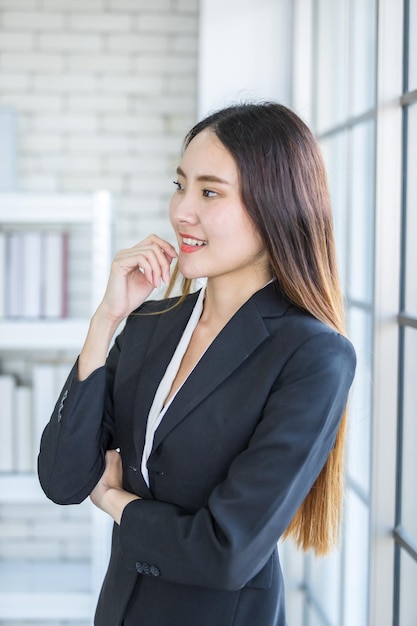 Portret wesołej dojrzałej azjatyckiej bizneswoman w tle w pokoju biurowymbiznes wyraził pewność siebie ośmiela się i udana koncepcja