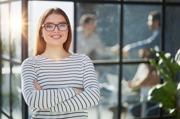 Portret wesołej młodej kobiety stojącej w urzędzie