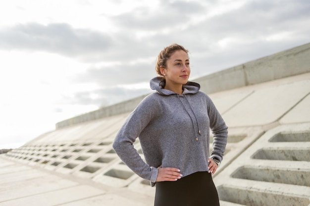 Portret wesołej, sportowej biegaczki w odzieży sportowej na świeżym powietrzu