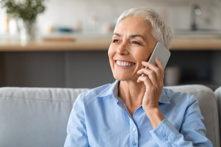 Zdjęcie portret wesołej starszej kobiety lubiącej rozmowy telefoniczne w domu
