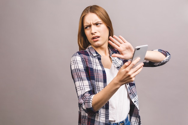 Zdjęcie portret wściekła smutna młoda kobieta używa telefon komórkowego. nie, znak stopu.