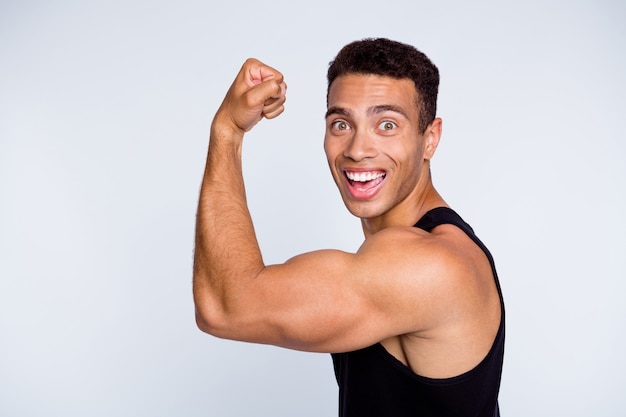 portret wysportowanego, męskiego, muskularnego faceta, demonstrującego potężne mięśnie podnoszące ciężary