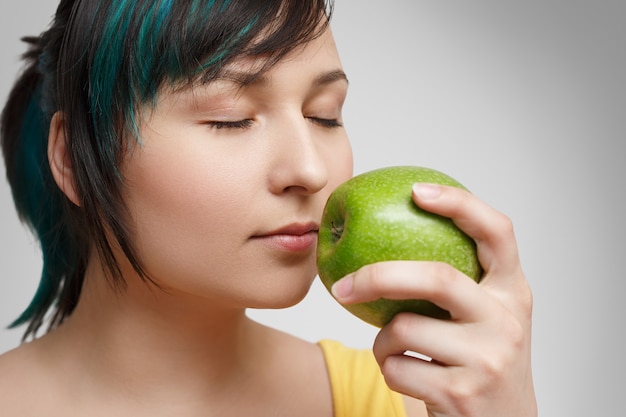 Portret z bliska. dziewczyna wąchająca jabłko.