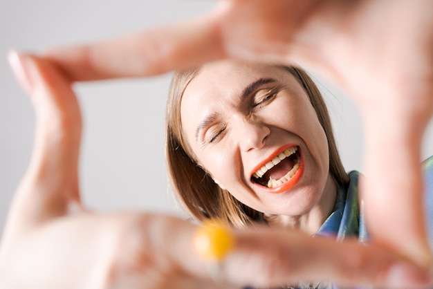 Zdjęcie portret z bliska emocjonalna urocza wesoła kobieta z jasnymi ustami pokazuj rękę