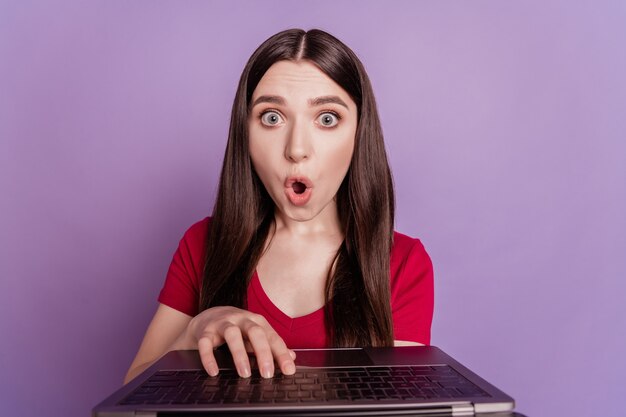 Portret Z Kamery Internetowej Podekscytowanej, Zszokowanej, Zafascynowanej Pani, Trzymającej Otwarte Usta Laptopa Na Fioletowym Tle