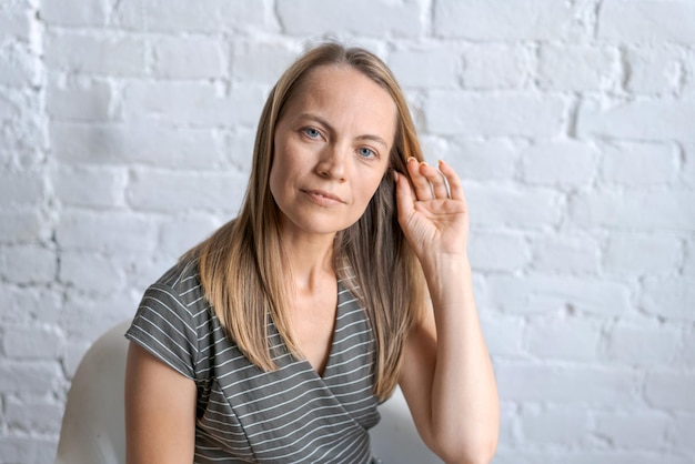 Portret z strzałem szczęśliwa w średnim wieku blond kobieta Uśmiecha się patrząc na kamerę