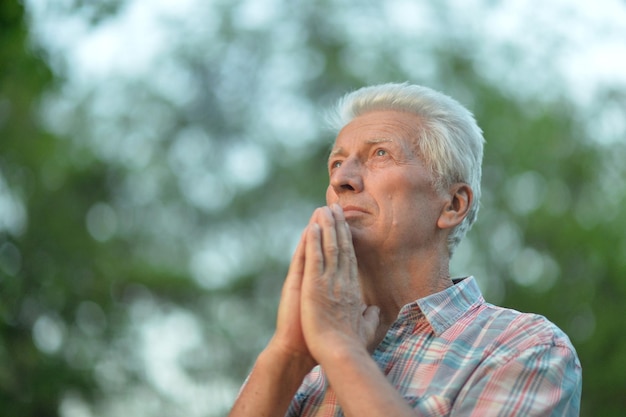 Portret zamyślonego starszego mężczyzny w parku