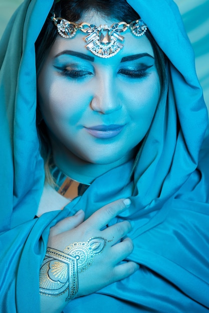 Zdjęcie portret zbliżenie wschodniej kobiety z niebieskim szalikiem. arabka.