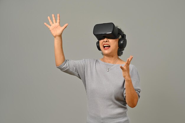 Portret zdumionej starszej kobiety Zestaw słuchawkowy VR cieszący się wirtualną rzeczywistością Nowoczesne technologie, innowacje i gadżety