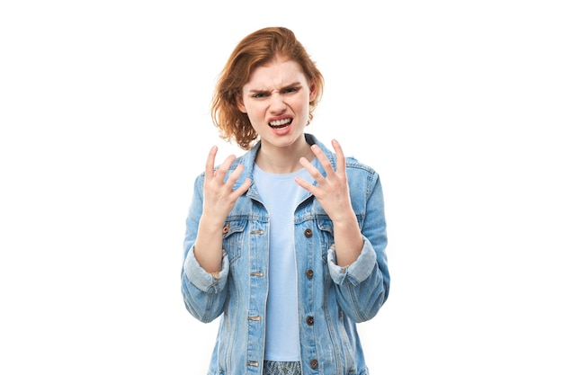 Portret zły rudzielec młoda kobieta krzyczy na białym tle na tle białego studia, pokazując negatywne emocjexA