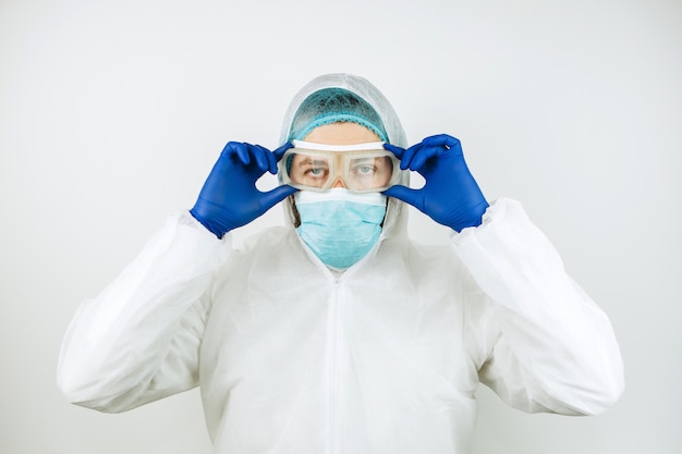 Portret zmęczona lekarka po zmiany w szpitalu. Lekarz w odzieży ochronnej - okulary, maska, rękawiczki. Lekarz leczący pacjentów z koronawirusem. Covid-2019