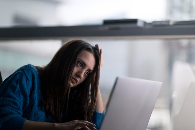 Portret znudzonej i niechętnej kobiety, która patrzy na laptopa w obojętnym nastroju