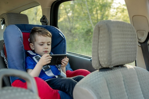 Portret Znudzony Mały Chłopiec Siedzi W Foteliku Samochodowym. Bezpieczeństwo Transportu Dzieci.