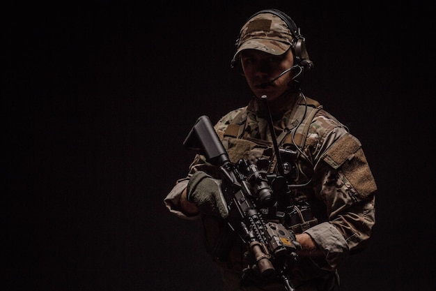 Portret żołnierza lub prywatnego wojskowego wykonawcy trzymającego karabin snajperski Technologia broni wojennej i koncepcja ludzi Obraz na czarnym tle