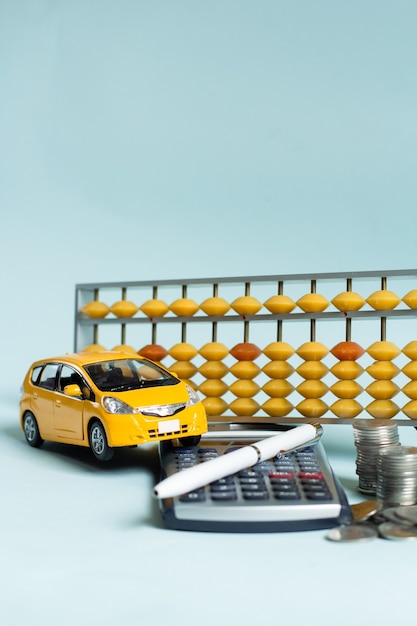 Zdjęcie portret żółtego liczydła i samochodu z koncepcją biznesową kalkulatora finansowego