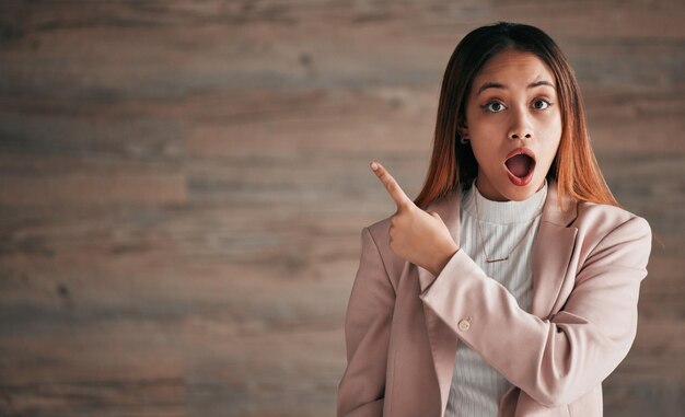 Portret zszokowanej kobiety i wskazujący na makietę w celu ogłoszenia reklamy lub marketingu Zaskoczona biznesowa kobieta wskazująca palcem, aby skopiować miejsce w szoku na reklamę na tle studia