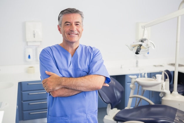 Portret życzliwy dentysta z rękami krzyżować