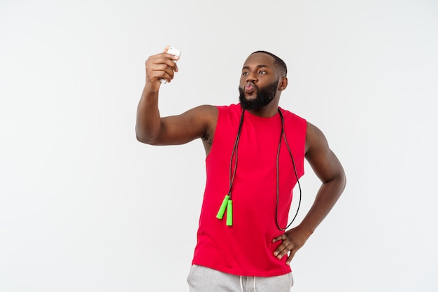 Portreta Szczęśliwy Młody Afrykański Mężczyzna Pozować Odizolowywam Nad Popielatym Bierze Selfie Telefonem Z Arkaną I Sport Odzieżą.