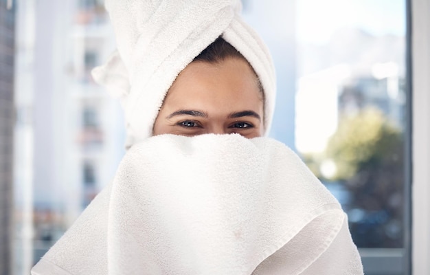 Portretowy ręcznik i kobieta po prysznicu szczęśliwi i zrelaksowani, ukrywając twarz i pielęgnację w swoim domu Nieśmiała dziewczyna i piękna pielęgnacja skóry i rutyna w łazience do czyszczenia higieny i zabawy w Nowym Jorku