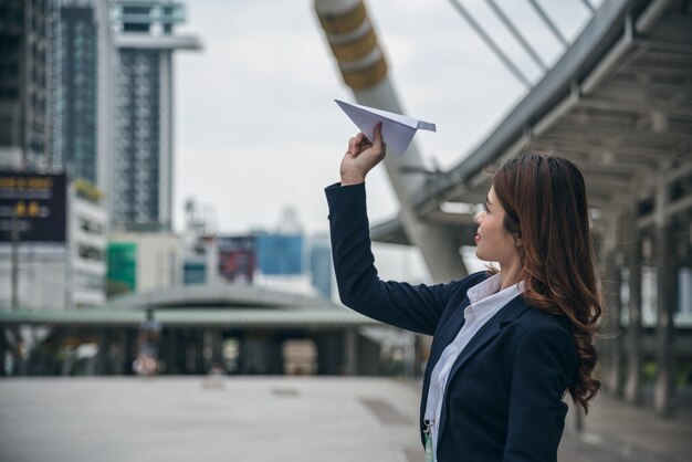 Portrety piękny azjatykci kobiety spojrzenia zaufanie są stojący papierowego samolot i trzymający