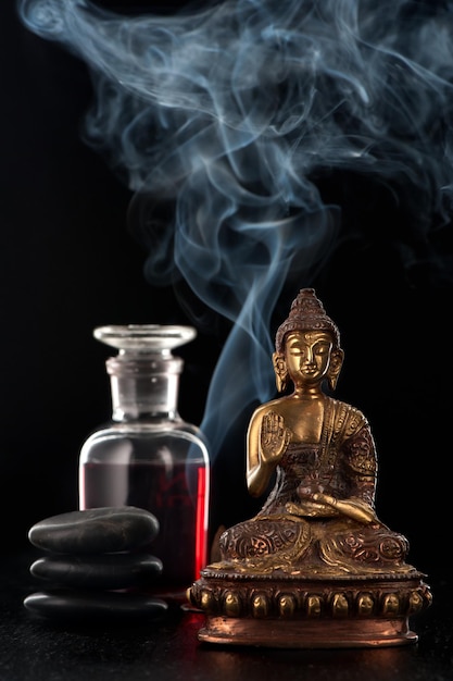 Posąg Buddy olejek różany i kamienie zen