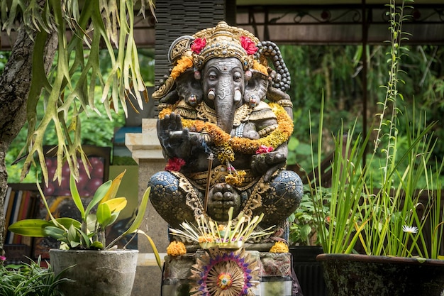 Posąg Ganesha ozdobiony kwiatami w świątyni w Ubud Bali Indonezja