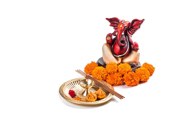 Posąg hinduskiego boga Ganesha z układem kultu na białej powierzchni.