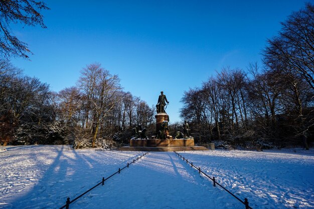 Posąg na pokrytym śniegiem krajobrazie na tle jasnego niebieskiego nieba