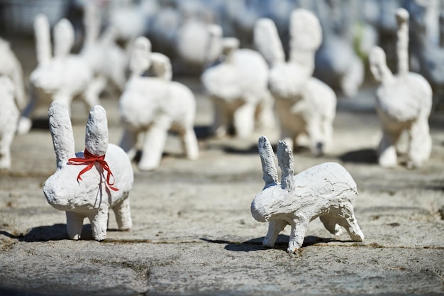 Posągi białego królika wykonane z gipsu na wystawie sztuki plenerowej śmieszne białe zające na ulicy