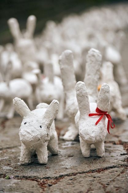 Posągi białego królika wykonane z gipsu na wystawie sztuki plenerowej śmieszne białe zające na ulicy