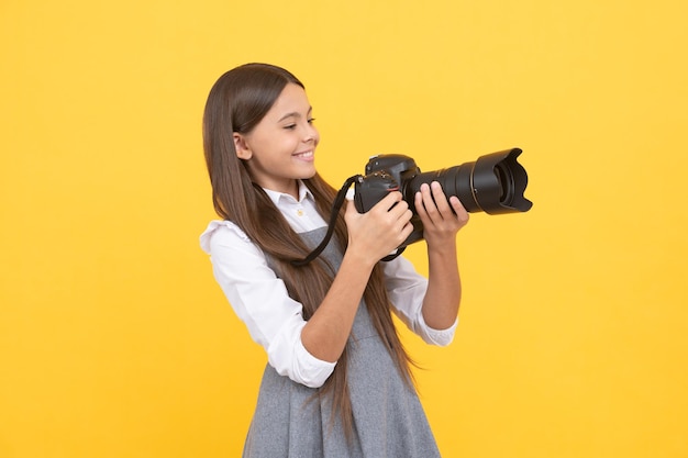 Posiadanie umiejętności migawka dzieciństwo nastolatka robiąca zdjęcie dziecko używa aparatu cyfrowego szczęśliwe dziecko fotografowanie hobby szkoła fotografii lub przyszła kariera fotograf początkujący z nowoczesnym aparatem