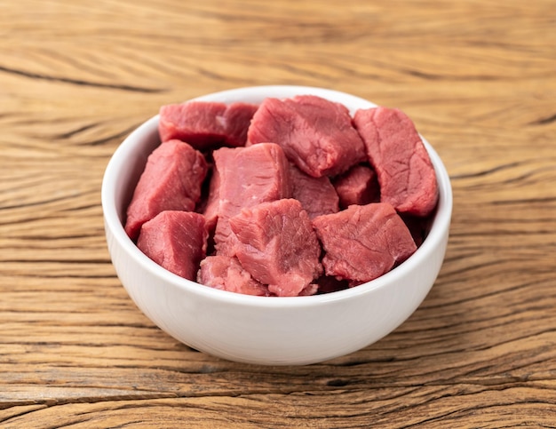 Posiekane mięso z wierzchu w misce nad drewnianym stołem
