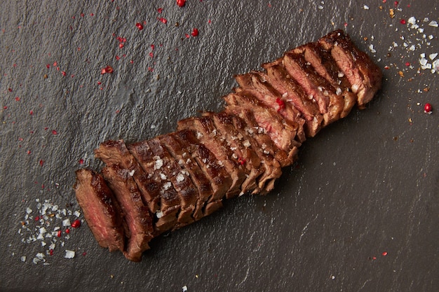 Posiekany smażony kotlet schabowy leży na czarnej desce