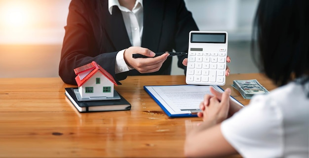 Pośrednicy w obrocie nieruchomościami obliczają koszt dla klienta, aby zgodzić się na podpisanie umowy wyjaśniającej warunki Pomysły dotyczące domu i nieruchomości