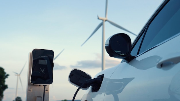 Postępująca przyszła koncepcja infrastruktury energetycznej, w której pojazd elektryczny jest ładowany na stacji ładowania zasilanej zieloną i odnawialną energią z turbiny wiatrowej w celu ochrony środowiska