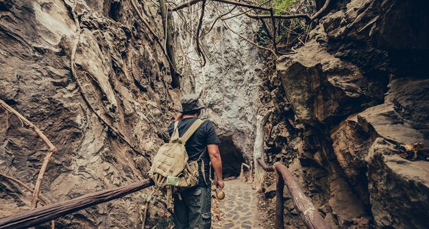 Poszukiwacz przygód trzymający lornetkę do obserwacji ptaków i szlaku turystycznego w lesie i jaskini. Aktywność na świeżym powietrzu i rekreacja na wakacjach.
