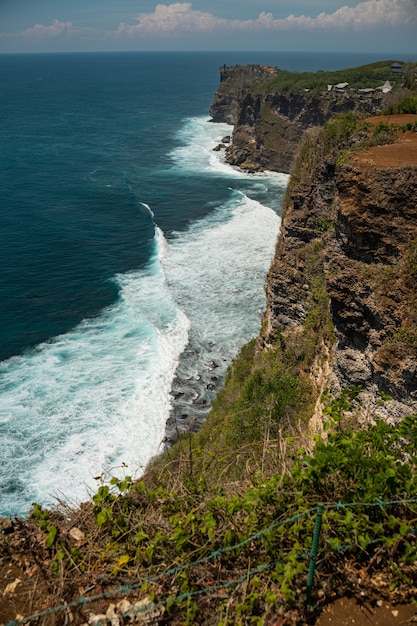 Potężne fale oceanu rozbijające się o skalisty brzeg na Bali