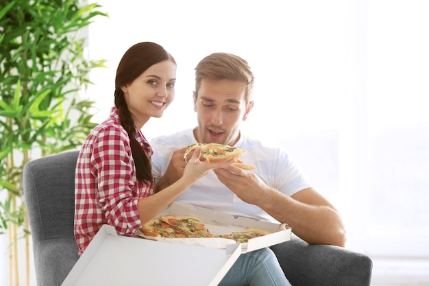 Potomstwo pary łasowania pizza w domu