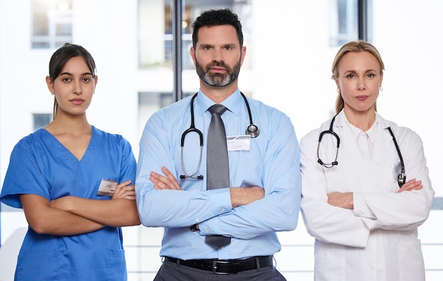 Potraktuj poważnie swoje zdrowie. Ujęcie grupy lekarzy stojących ze skrzyżowanymi rękami w szpitalu.