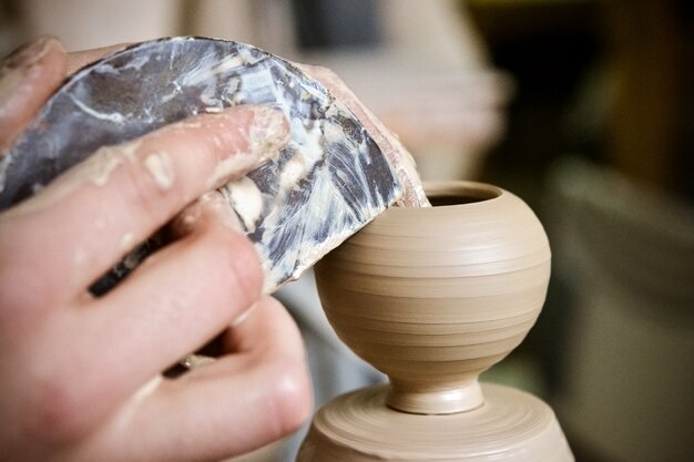 Potter robi z gliny ładny mały wazon