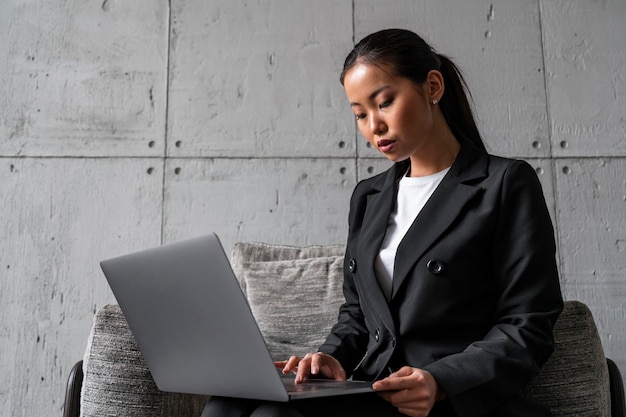 Poważna azjatycka bizneswoman używająca laptopa