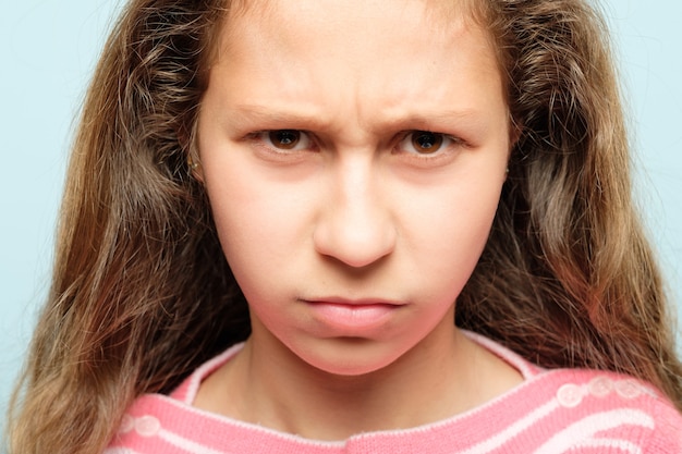 Zdjęcie poważna młoda dziewczyna z gniewnym, niezadowolonym spojrzeniem i zmarszczonymi brwiami. koncepcja emocji i uczuć.
