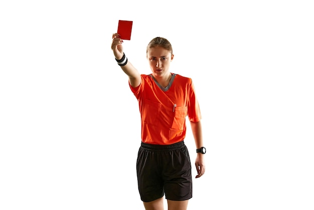 Poważna młoda sędzia piłkarska w mundurze pokazująca czerwoną kartkę jako symbol zwolnienia na tle bieli