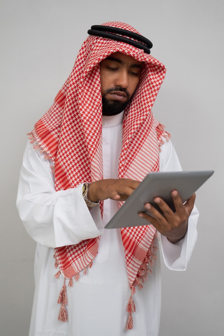 Zdjęcie poważny arab w turbanie używający podkładki