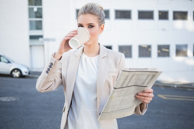 Poważny elegancki bizneswoman pije kawę